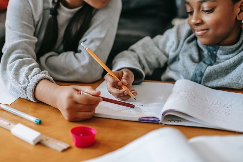 enfant aidé par un professeur pour ses devoirs à domicile