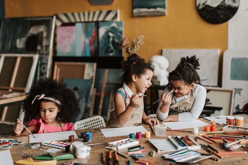 3 enfants en train de peindre dans un atelier
